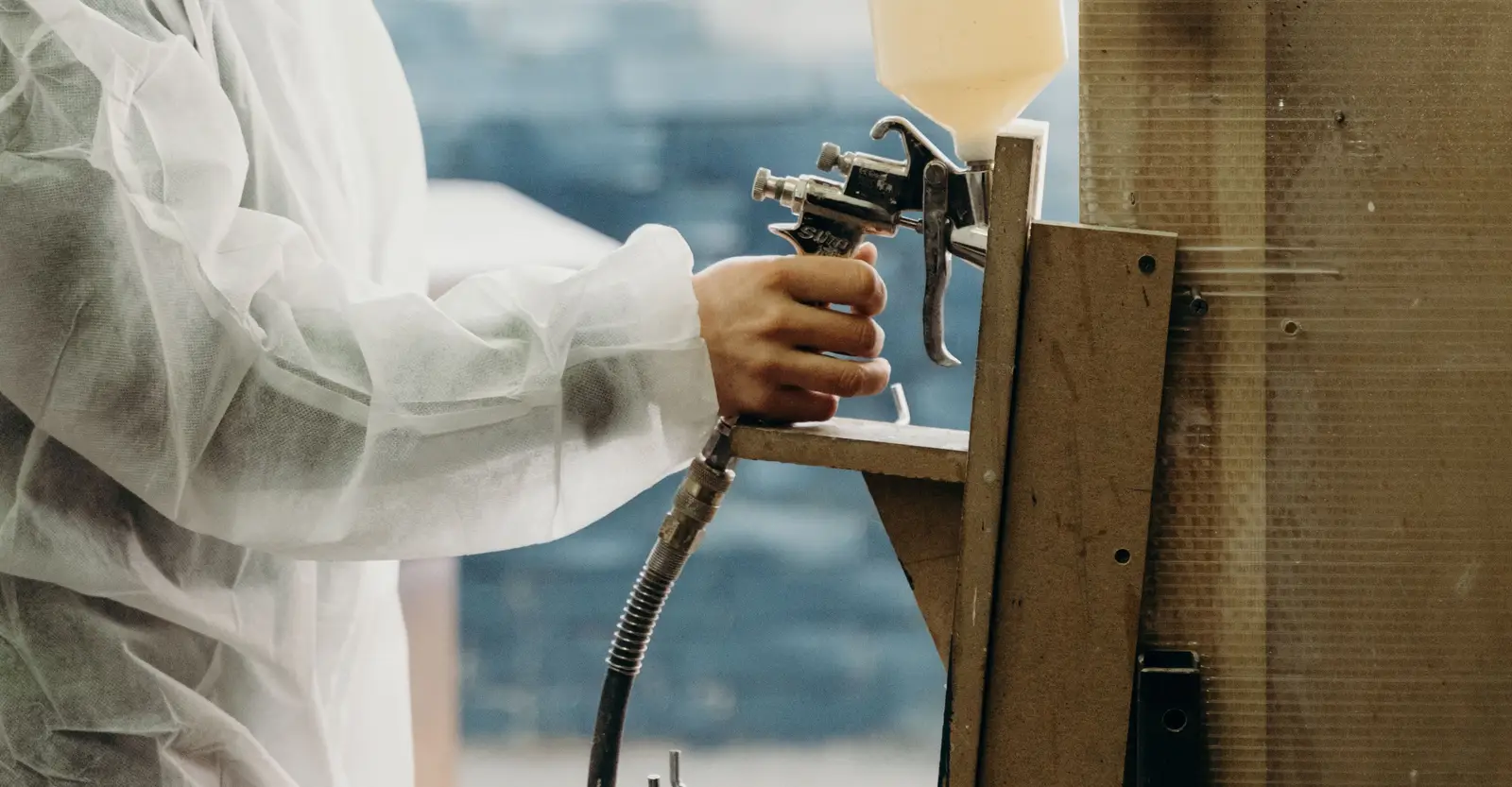Finisher in protective gear using a spray gun